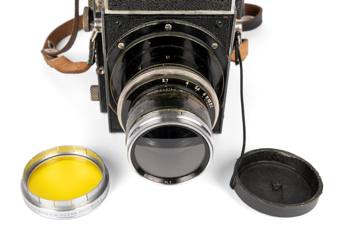 Primarflex 6x6 kamera med polstret skinnveske, bruksanvisning og 2 filter.
Objektiv/ Linse: D.R.P.Dr.Rudolph Hugo Meyer & Co Görlitz Nr. 584973. MakroPlasmat 1:27, f=10.5 cm.

Metallkropp dekt med lær på utsiden. Skinnreim. På toppen en belg som spretter opp ved å trykke på en liten knapp. Ellers flere justeringsknapper på høyre side.
Serienummer: 25608.