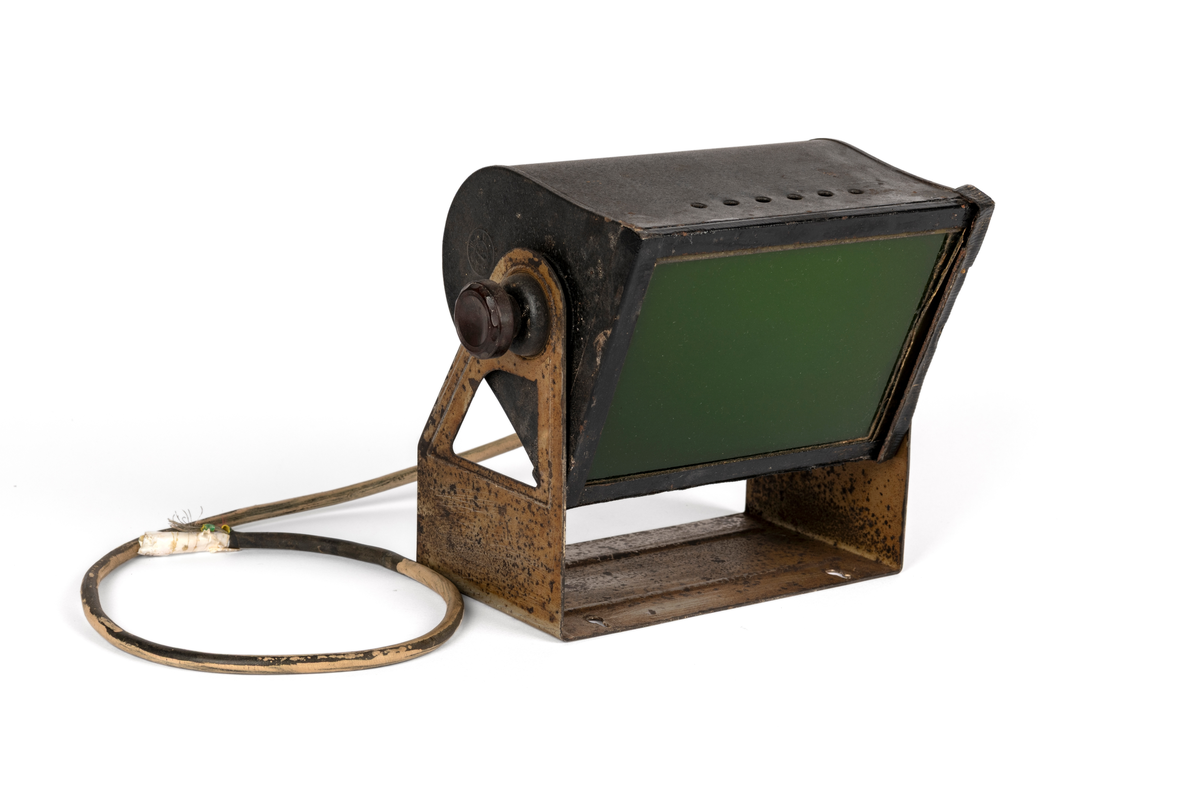 Mørkeromslampe med stativ og ledning. Brukt av Martin Velle i hans butikk i Ørsta. Lampa har glas som kan trekkast ut og skiftast til anna farga glas. Sjå eiga registrering av lysfilter.