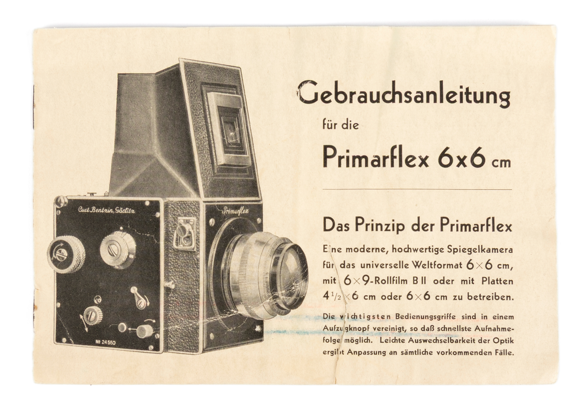 Primarflex 6x6 kamera med polstret skinnveske, bruksanvisning og 2 filter.
Objektiv/ Linse: D.R.P.Dr.Rudolph Hugo Meyer & Co Görlitz Nr. 584973. MakroPlasmat 1:27, f=10.5 cm.

Metallkropp dekt med lær på utsiden. Skinnreim. På toppen en belg som spretter opp ved å trykke på en liten knapp. Ellers flere justeringsknapper på høyre side.
Serienummer: 25608.