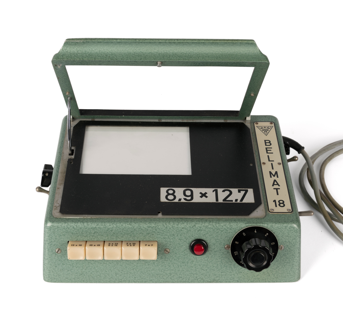 Kontaktkopieringsapparat med to straumfordelarar til prosjektor/ mørkeromslampe. Fleire innstilling- og justeringsknappar. Med tilhøyrande deksel i plast.