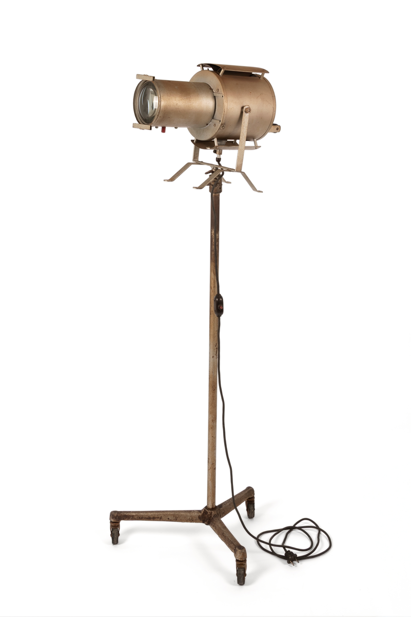 Spotlys med stativ og beholder for matriser/ filter som lyset skinner igjennom. Brukt som visuelt virkemiddel i bakgrunnen ved portrettfotografering.