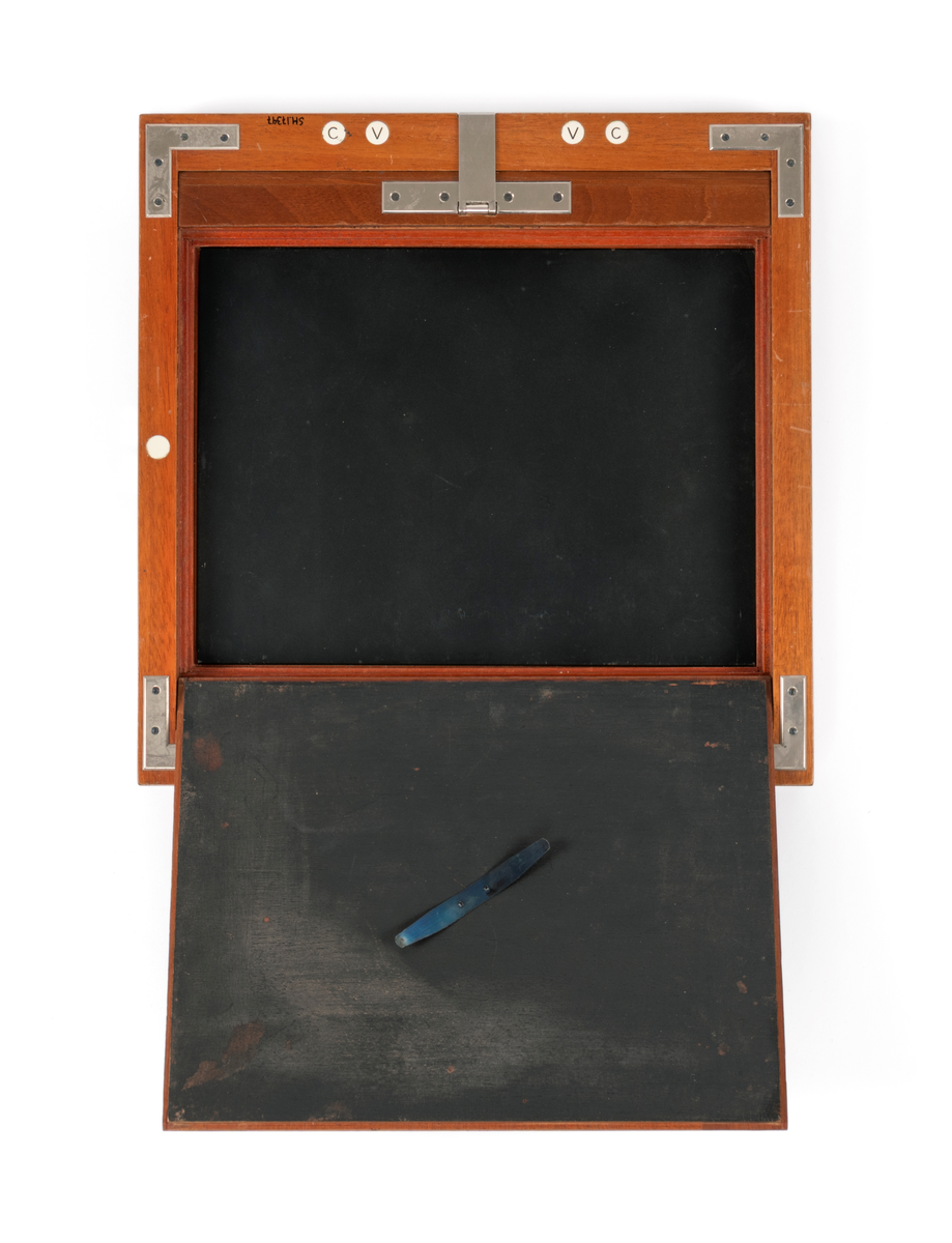 Filmkassett tilhørende atelierkamera. 17x23cm negativ planfilm/glas. Med glasplate til å stille skarpt.