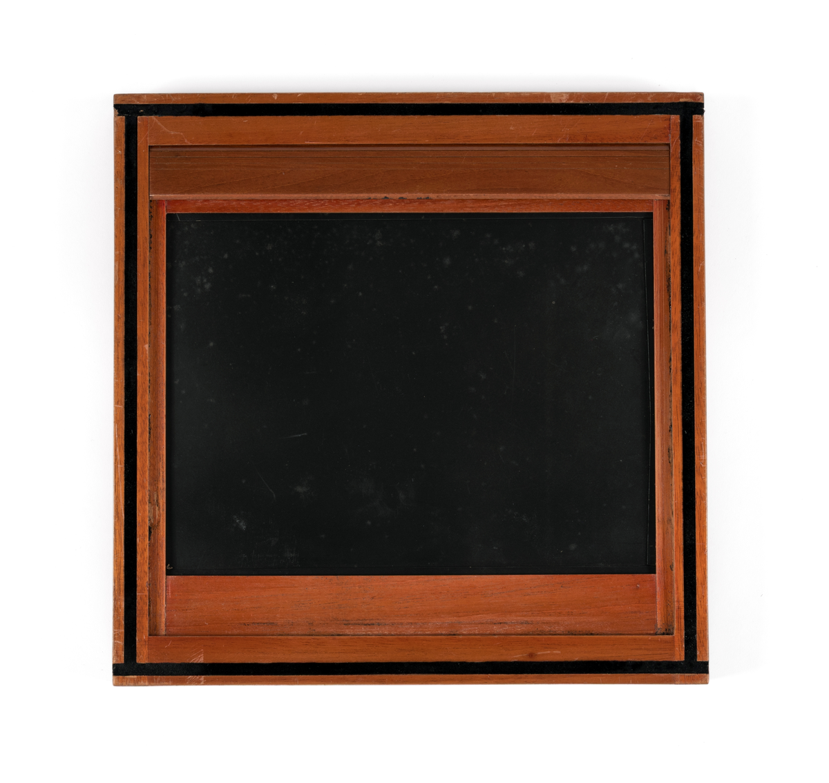 Filmkassett tilhørende atelierkamera. 17x23cm negativ planfilm/glas. Med glasplate til å stille skarpt.