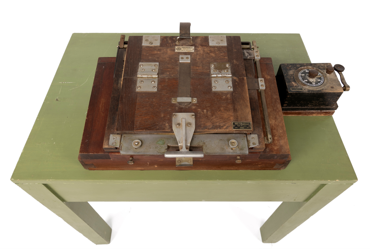 Kontaktkopieringsapparat brukt av Martin Velle i hans mørkerom. Apparatet er montert på eit bord med innebygd lampe og eit tidsur.