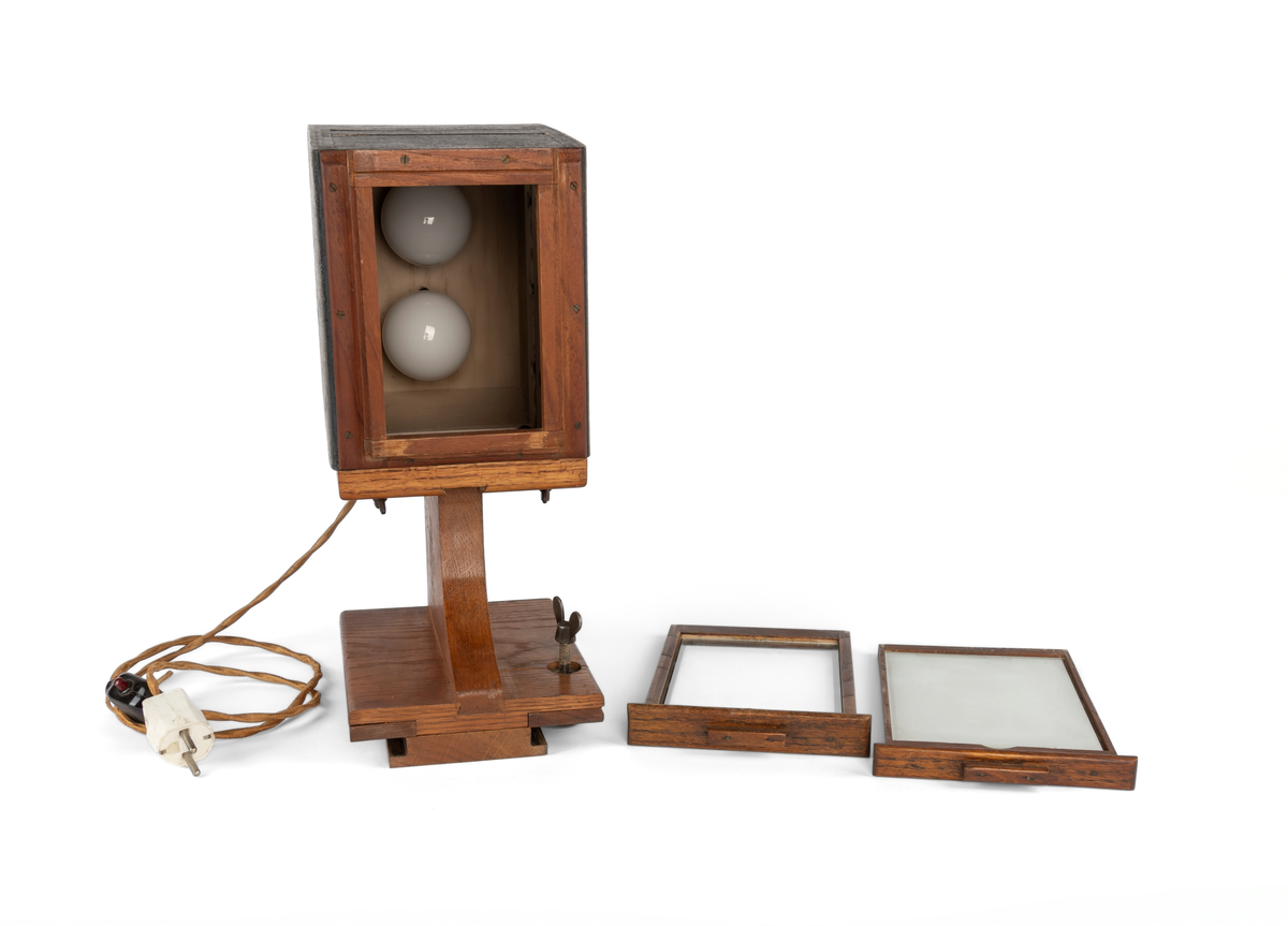 Forstørrelsesapparat brukt til framkalling av større bilder fra 10x15 cm negativ/glasplate. 2 lyspærer.