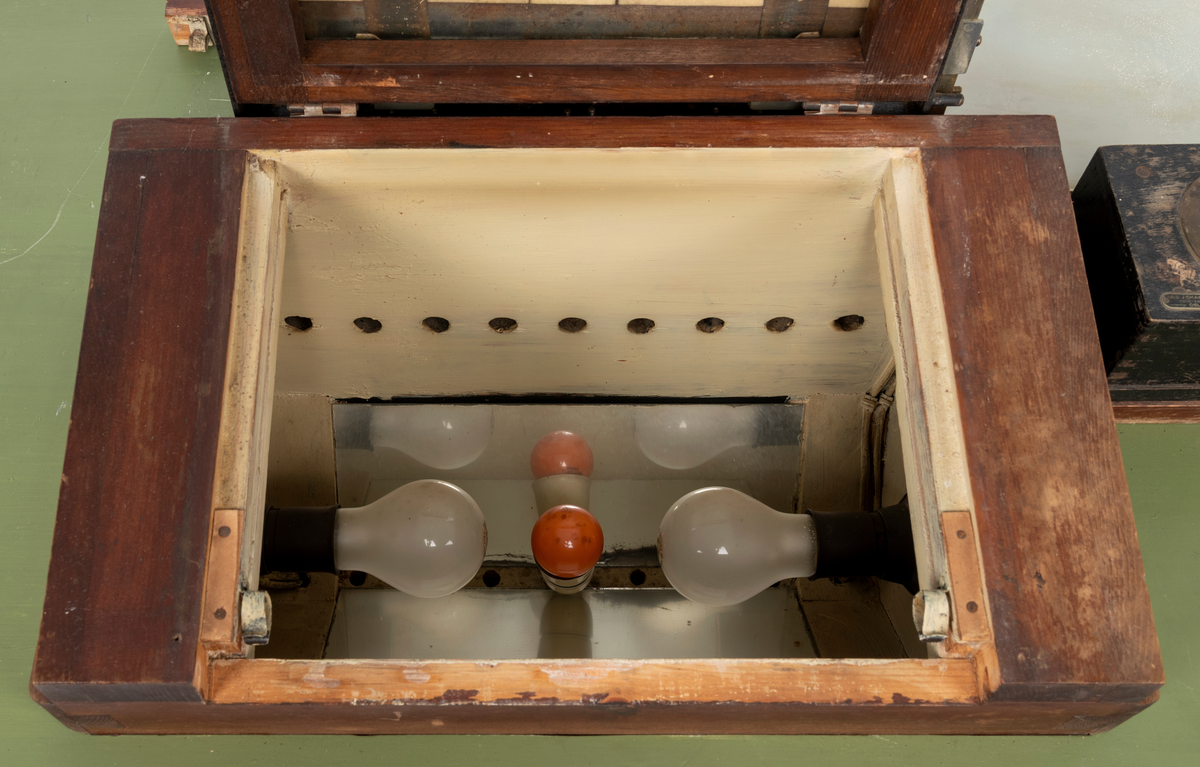 Kontaktkopieringsapparat brukt av Martin Velle i hans mørkerom. Apparatet er montert på eit bord med innebygd lampe og eit tidsur.