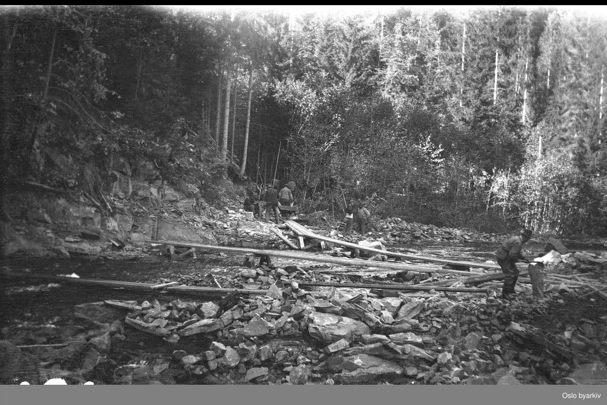 Bildet er tatt under arbeidet med forlengelsen av Lilleakerbanen til Bekkestua og Haslum. Forlengelsen stod ferdig 1924. Provisoriske broer over Lysakerelva.