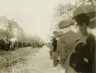 Biskop N.J.O.H. Lindströms begravning i oktober 1916. Begravningståget rör sig längs Linnégatan. Mycket folk har samlats.
I bakgrunden syns bl a Riksbankens hus (kv. Lyktan) t.v. och till höger gamla Flickskolan.
