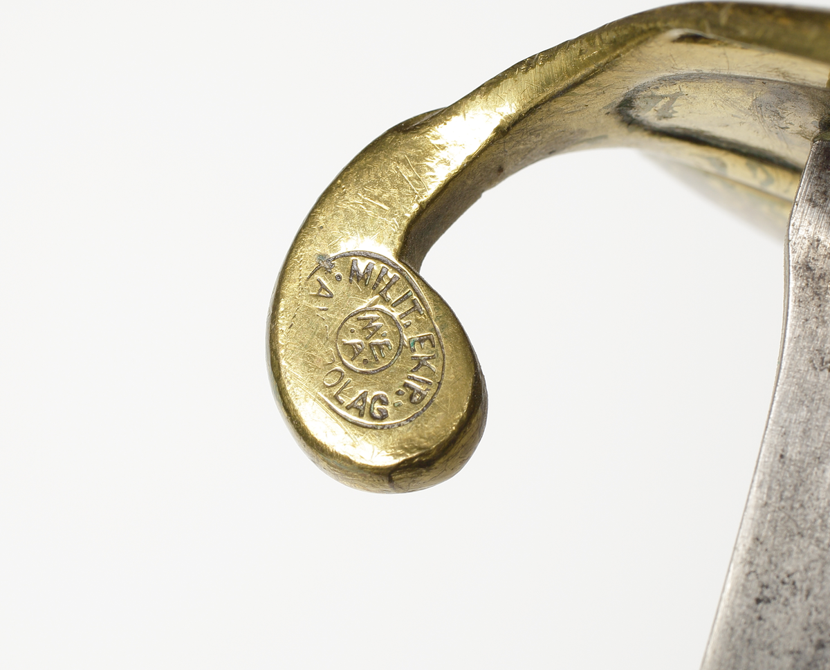 Sabel, marinhuggare, från 1800-talets slut. Tillverkare E Svalling Eskilstuna för M.E.A. 
Kort modell för marinens officerare. Kavel av läder med virad mässingstråd. Parerplåt, ryggbeslag och bygel av mässing. På parerplåten finns ett krönt ankare. 
Balja av svart skinn med munbleck och släpsko av mässing. 

Inskrivet i huvudbok år 1974.