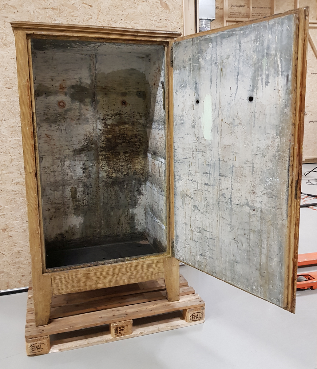 Et stående skap bygd av tre, innvendig kledd med sink.