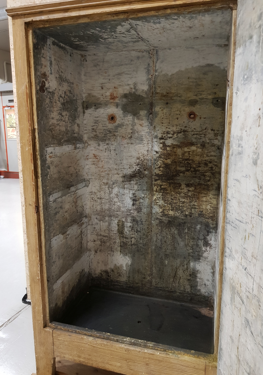 Et stående skap bygd av tre, innvendig kledd med sink.