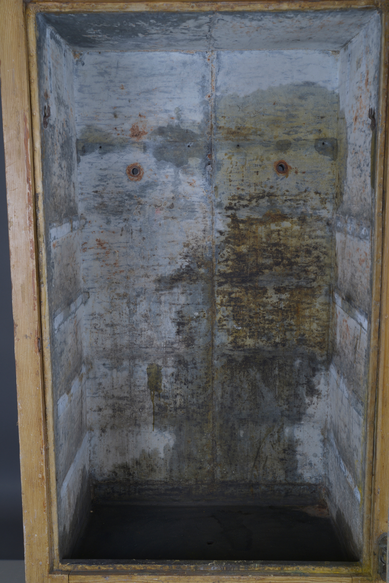 Et stående skap bygd av tre, innvendig kledd med sink.