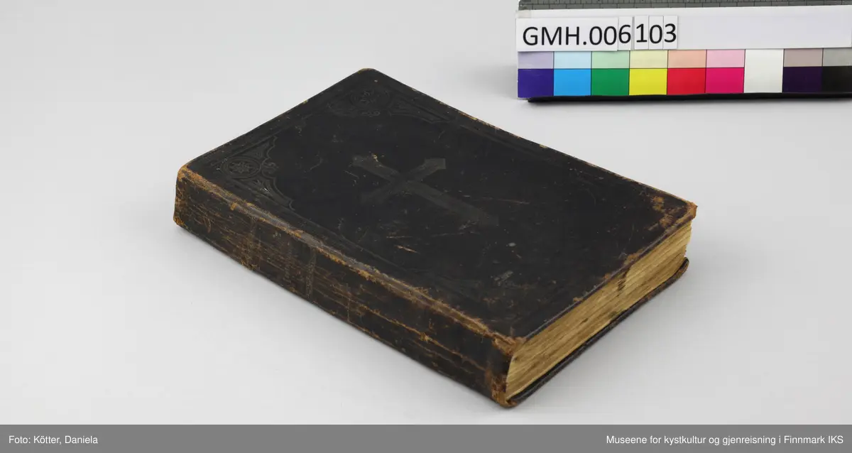 Det nye testamente på nordsamisk, utgitt 1895 i Kristiania. Boka har omslag av mørkebrunt skinn. På for- og baksiden er det innpreget ornamentrammer. På forsiden er det i tillegg preget inn et kors. På bokryggen er det preget inn tittelen "Ođđa Testamenta" og to ornamentbånd. Begge elementer viser rester etter forgylling. Bindingen er utført med tråd.  Det er innskrevet forskjellige navn. På første side står det Mauritz og et etternavn som er vanskelig å tyde. På siste side står det, i tillegg til noen regnestykker som er skrevet opp ned på sida, navnet «Ellen Marie Martensen» samt Sletten, som kan tilhøre familienavnet eller tyde på et sted, slik som inskripsjon "Pallklubben". Bibelen stammer fra samme dødsbo som brevet og bilder fra Emilie Andersen i aksesjon GMH2025-002.