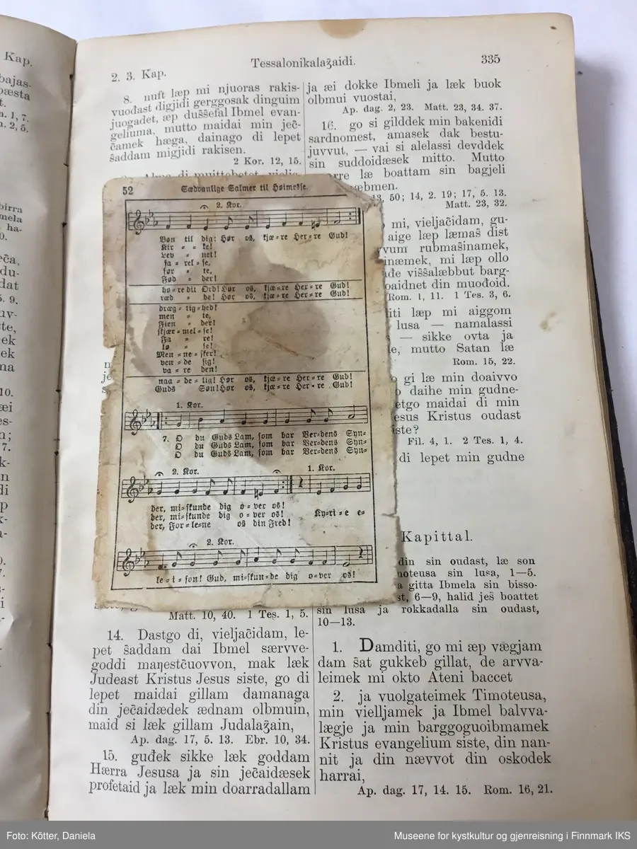 Det nye testamente på nordsamisk, utgitt 1895 i Kristiania. Boka har omslag av mørkebrunt skinn. På for- og baksiden er det innpreget ornamentrammer. På forsiden er det i tillegg preget inn et kors. På bokryggen er det preget inn tittelen "Ođđa Testamenta" og to ornamentbånd. Begge elementer viser rester etter forgylling. Bindingen er utført med tråd.  Det er innskrevet forskjellige navn. På første side står det Mauritz og et etternavn som er vanskelig å tyde. På siste side står det, i tillegg til noen regnestykker som er skrevet opp ned på sida, navnet «Ellen Marie Martensen» samt Sletten, som kan tilhøre familienavnet eller tyde på et sted, slik som inskripsjon "Pallklubben". Bibelen stammer fra samme dødsbo som brevet og bilder fra Emilie Andersen i aksesjon GMH2025-002.
