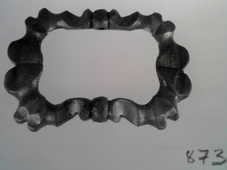 messing. stol og torn mangler. tilnærmet rektangulær. ornert på oversiden med brust C-er og hjerteformer.