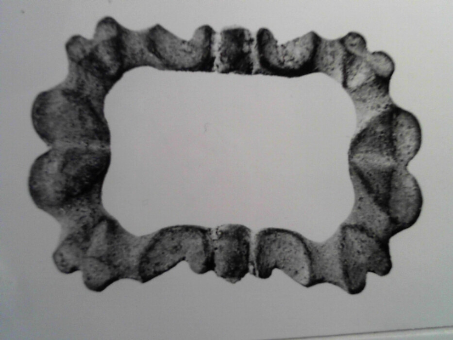 messing. stol og torn mangler. tilnærmet rektangulær. ornert på oversiden med brust C-er og hjerteformer.
