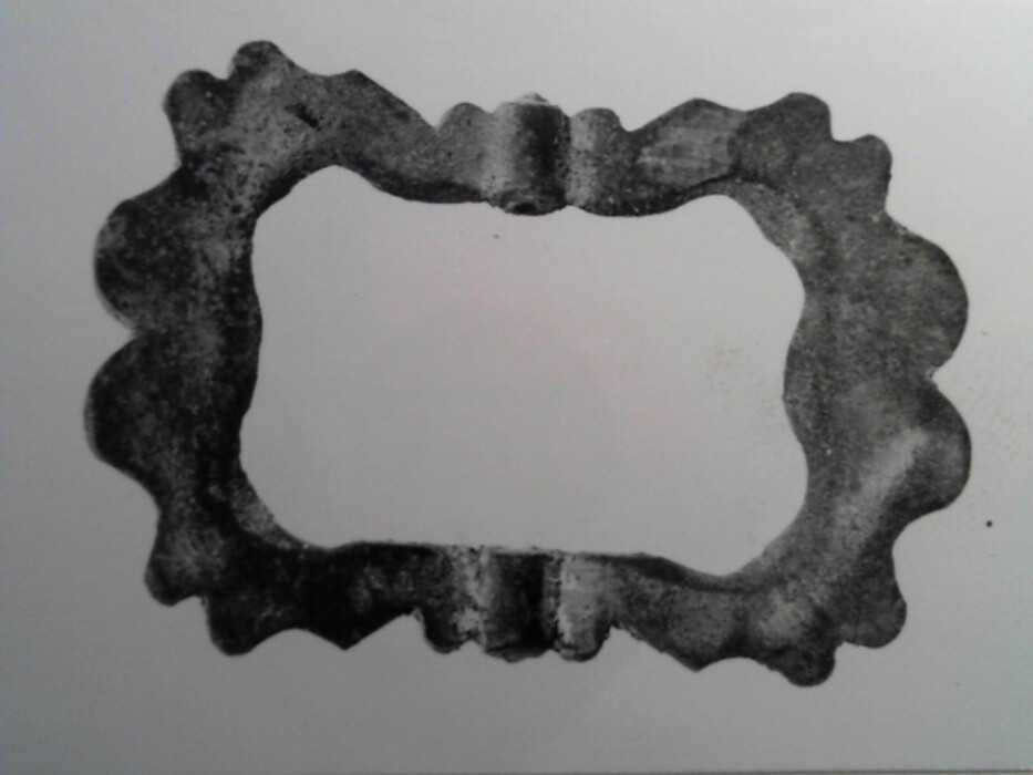 messing. stol og torn mangler. tilnærmet rektangulær. ornert på oversiden med brust C-er og hjerteformer.