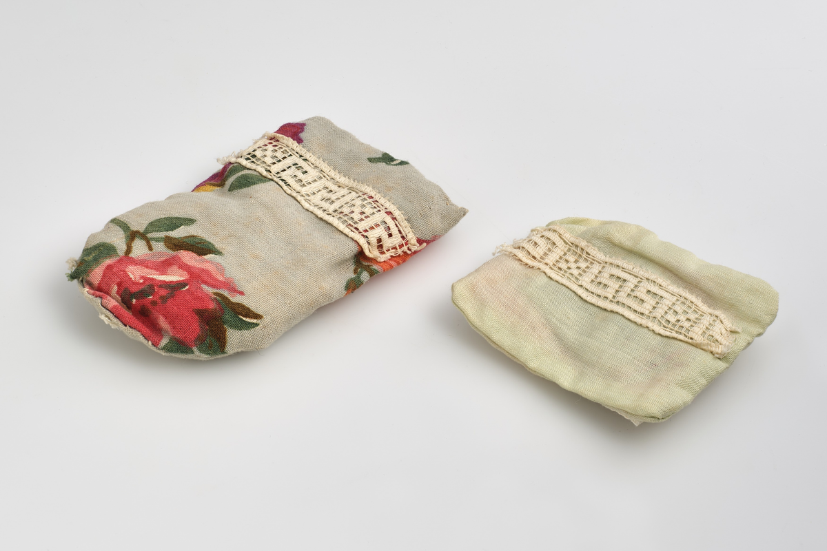 Leketøysseng til dukkehus, tilhørt en lekestue på 1930-tallet.
Sengen består av tre individuelle løse deler; sengeramme, pute og dyne.
Sengerammen er av tre, malt kremhvit, og limt sammen av 5 deler; to endesider, to sengekanter, og en plate. 
Endesiden ved sengens hodeende, er dekorert med et inngravert mønster malt i gull, mønsteret er bygd opp av en trekant øverst i midten, med to korte streker over hverandre på begge sider ut mot kanten, og en større firkant under, uten understrek. Endesiden i fotenden er noe lavere enn ved hodeenden, og dekorert på tilsvarende måte på utsiden. Kantene langs sengen er skjært ut rette, med forhøyning mot endesidene. Alle delene er limt rundt platen som utgjør bunnen av sengen. På undersiden av platen er det skrevet inn en strek med et seks-tall på hver side, med blyant.
Puten er sydd sammen av et lysegrønt stoff, dekorert med et blonde-bånd som streker seg over ca. midten av puten. Puten er generelt preget av misfargin.
Dynen er sydd sammen av et blått blomster-dekorert stoff, og pyntet med samme blonde-bånd som strekker seg over topp-delen av dynen. Formmessig er dynen tilsvarende rektangulær, med en avrundet ende i fotenden.