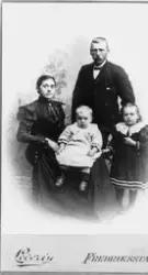 Gruppeportrett av familie i fotoatelier. Nilsine (1870-1945)