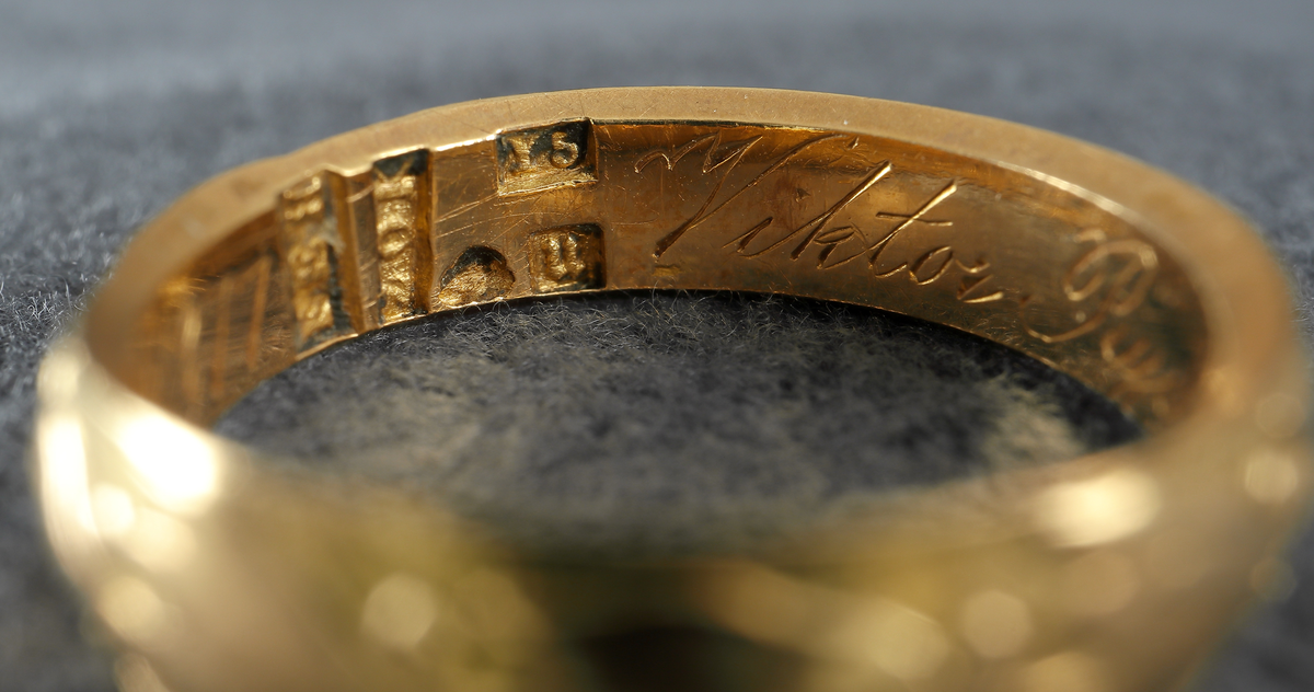 Doktorsring av guld med lagerkransmönster. Tillhört Viktor Rydberg. Ringen har utvändigt ett lagerkransmönster. Invändigt har den texten "Viktor Rydberg D. Phil. Honor 18 6/9 77". Den är försedd med stämplar, kontrollstämpel, 20K, stadsstämpel (Växjö), mästarstämpel (EEH) och årtalsstämpel Y5 (1877).
Inskrivet i huvudbok 1984.