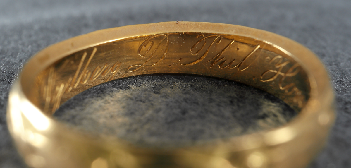 Doktorsring av guld med lagerkransmönster. Tillhört Viktor Rydberg. Ringen har utvändigt ett lagerkransmönster. Invändigt har den texten "Viktor Rydberg D. Phil. Honor 18 6/9 77". Den är försedd med stämplar, kontrollstämpel, 20K, stadsstämpel (Växjö), mästarstämpel (EEH) och årtalsstämpel Y5 (1877).
Inskrivet i huvudbok 1984.