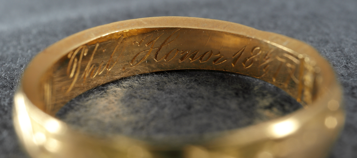 Doktorsring av guld med lagerkransmönster. Tillhört Viktor Rydberg. Ringen har utvändigt ett lagerkransmönster. Invändigt har den texten "Viktor Rydberg D. Phil. Honor 18 6/9 77". Den är försedd med stämplar, kontrollstämpel, 20K, stadsstämpel (Växjö), mästarstämpel (EEH) och årtalsstämpel Y5 (1877).
Inskrivet i huvudbok 1984.