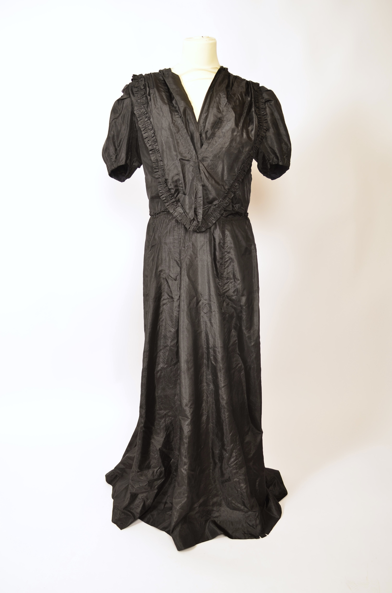 Selskapskjole av sort silkestoff.