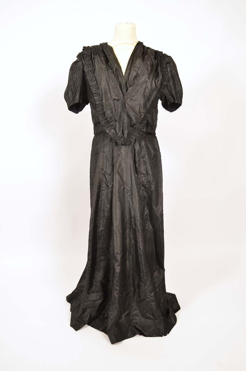 Selskapskjole av sort silkestoff.