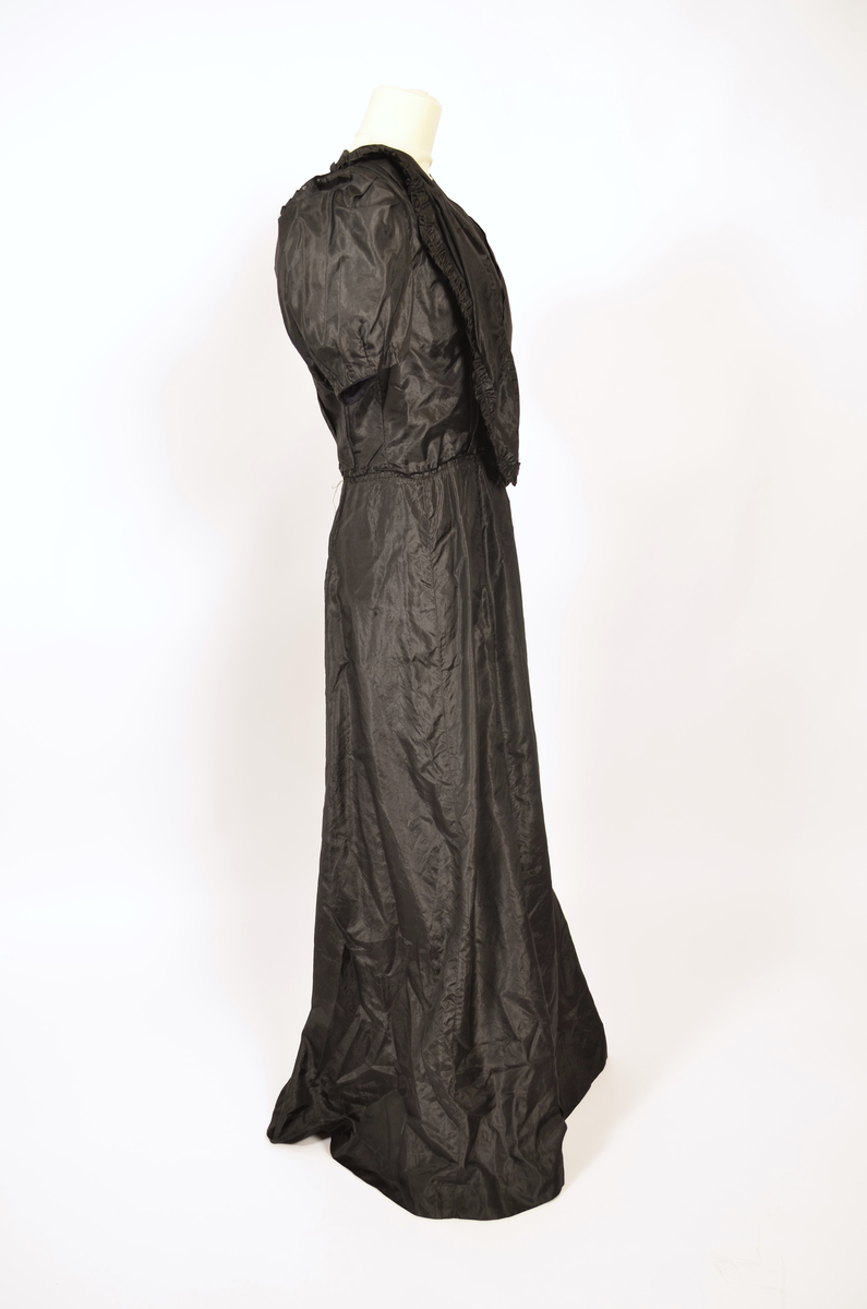 Selskapskjole av sort silkestoff.