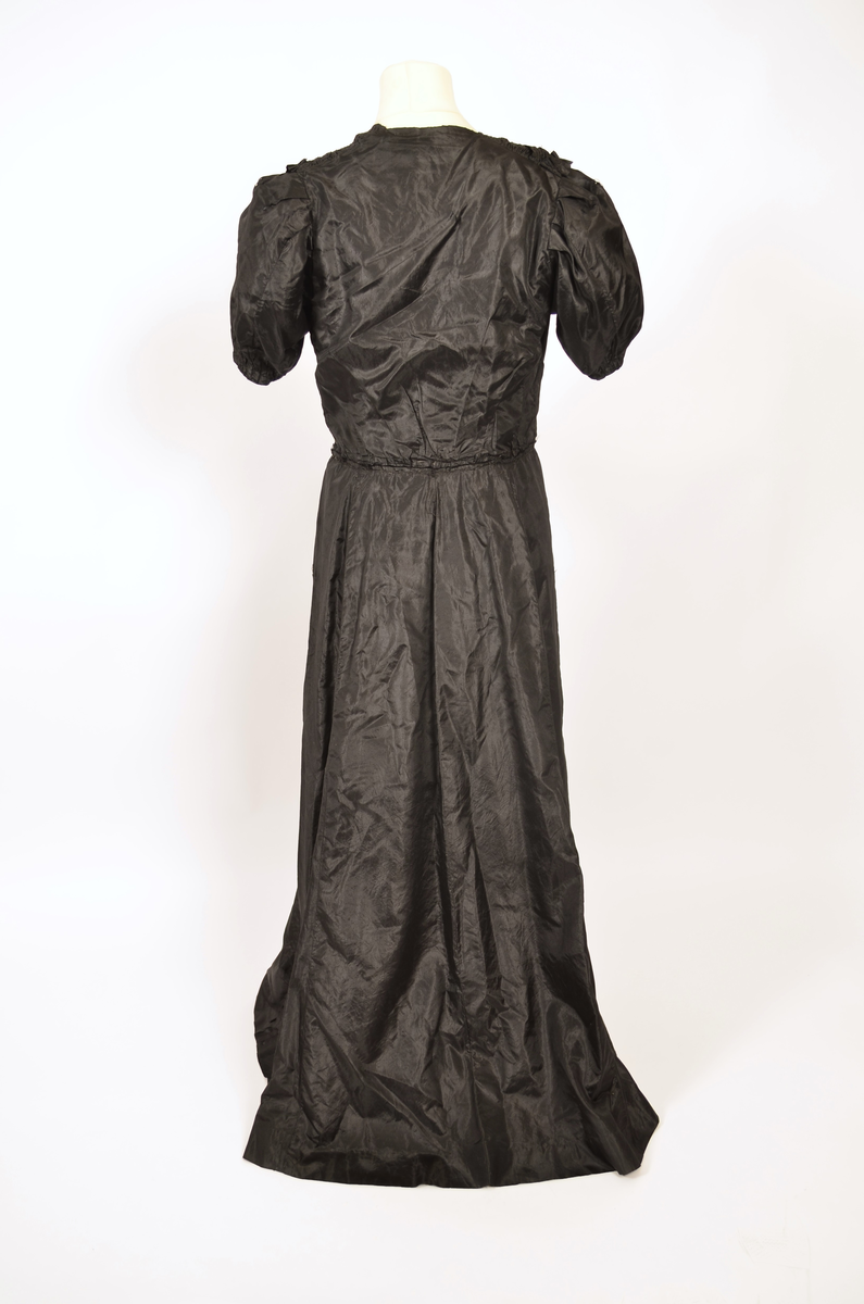 Selskapskjole av sort silkestoff.