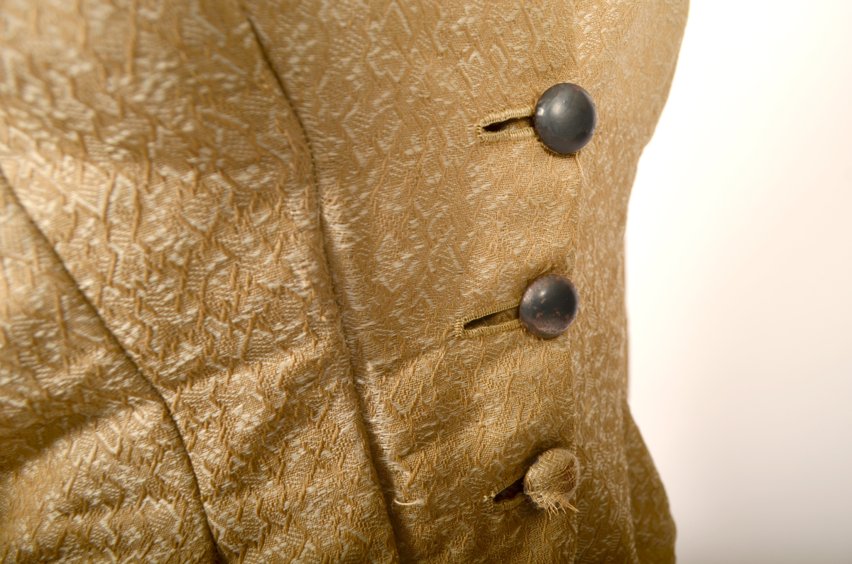 drakt. Fotvidt skjørt. Vid jakke. Fihursydd. Beige mønstret. Kappe på skjørt. Sløyfer på ermer.