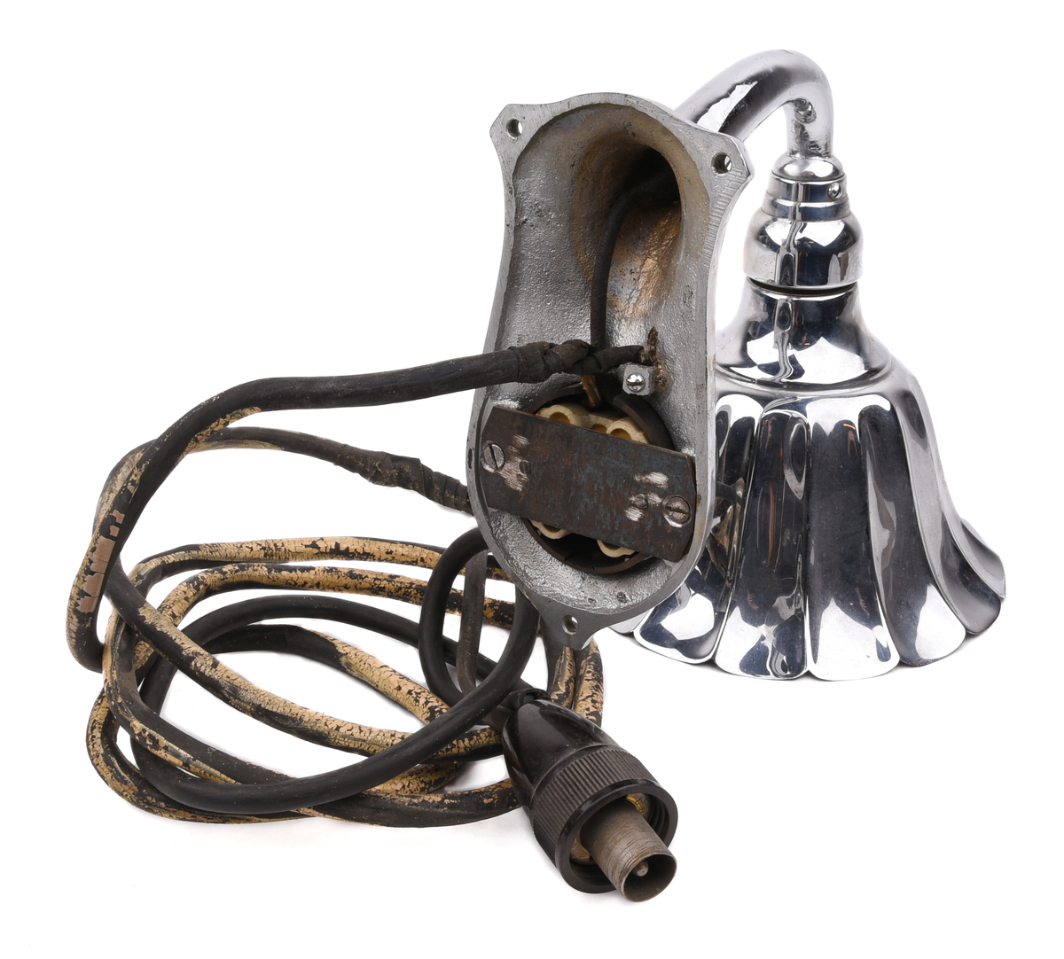 Elektrisk armatur av metall. Troligen modell nr 3050 (SJ typ X), tillverkad av Bröderna Malmströms Metallvarufabrik.
Beskrivning från deras katalog över Järnvägsarmaturer från 1934:
"Fästplattans höjd 160 mm, största bredd 80 mm. Största avstånd från väggen 230 mm. Utföres i gjuten mässing. Skärmen av mässingsplåt, 155 mm diam., invändigt vitlackerad. Lamphållaren är av samma konstruktion som hos n:r 3035, således Edisongänga och fjädrande bottenkontakt. Avsedd för max. 40 volt. Strömbrytaren av typ "Membra". Kan även levereras med normal bajonettlamphållare."