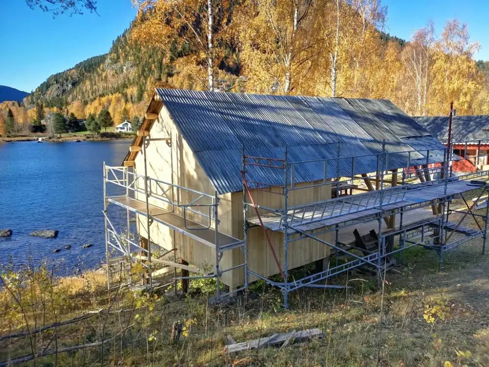 gamal bygning med stillas rundt ved vatnet