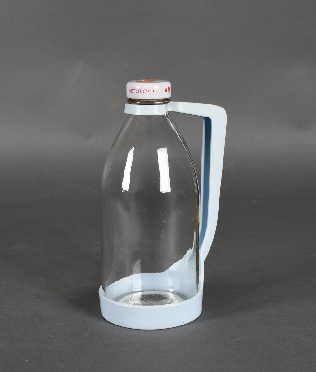 Flaske i klart glass, med lyseblå plastholder og hvit plastkork med rød tekst.