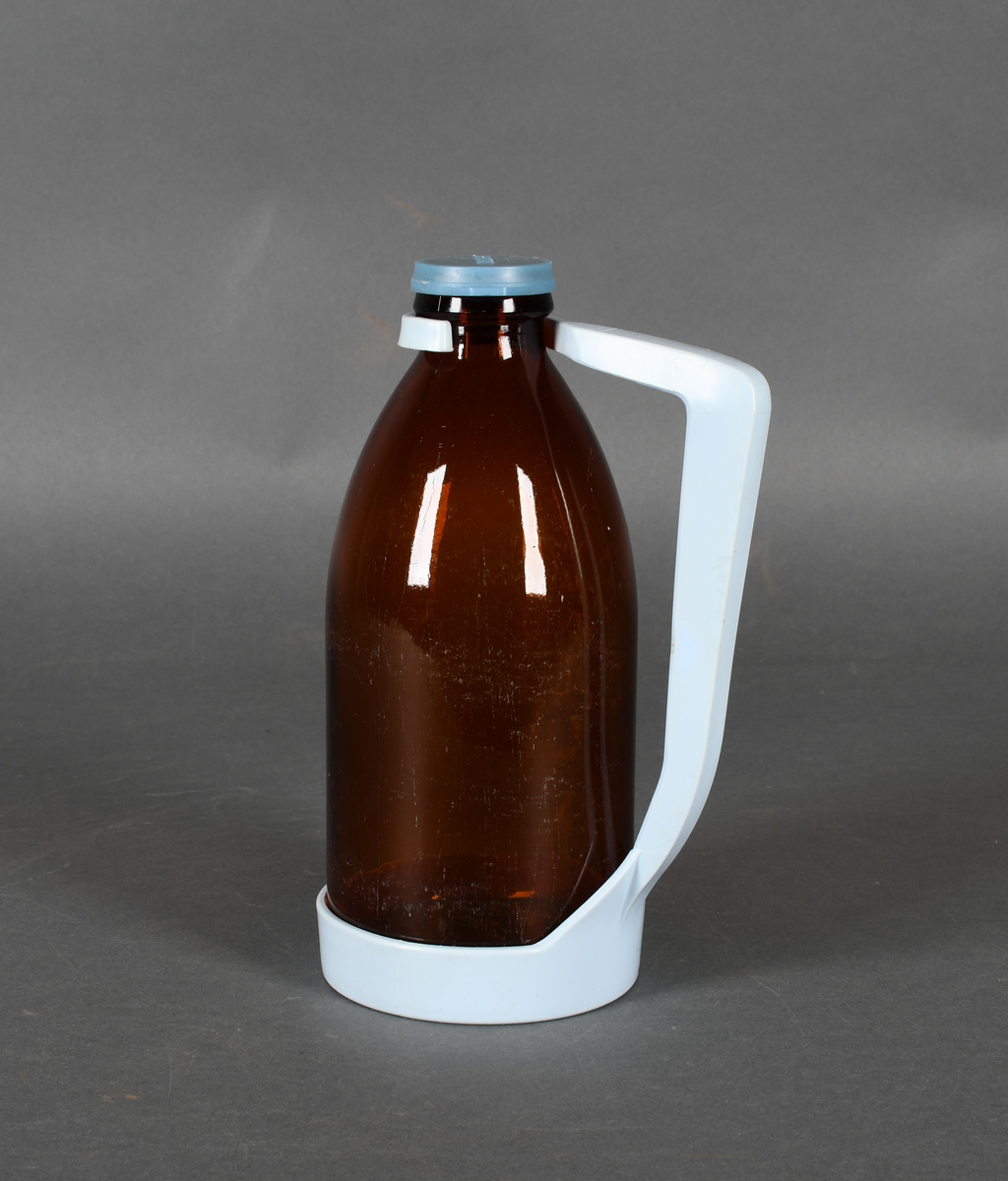 Flaske i brunt glass, med lyseblå plastholder og mellomblå plastkork.