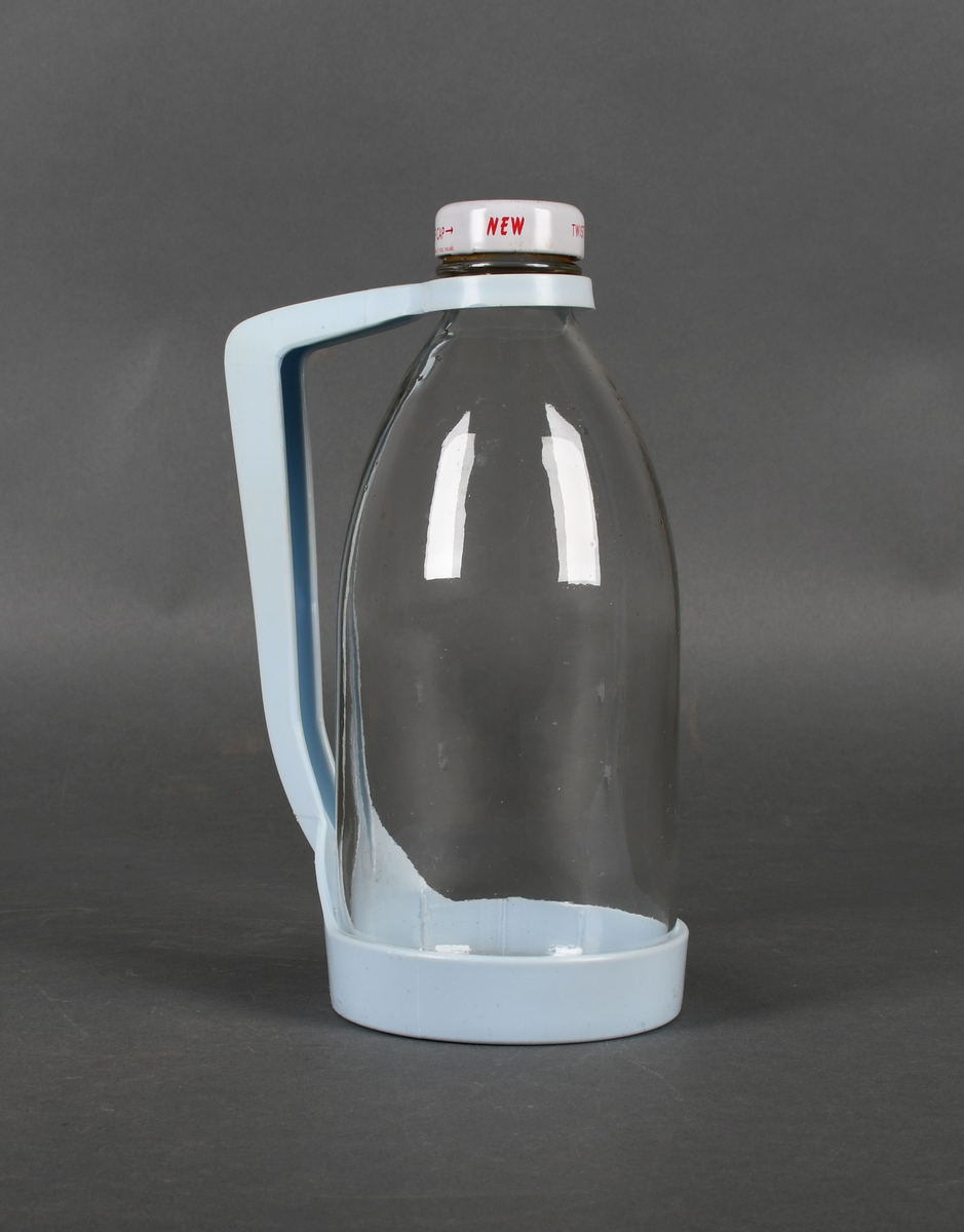 Flaske i klart glass, med lyseblå plastholder og hvit plastkork med rød tekst.