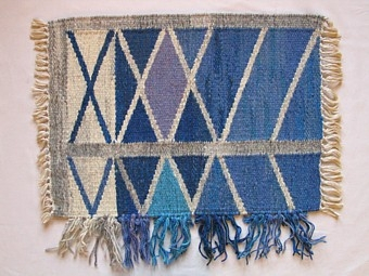 Mattprovet är vävt i rölakansteknik.
Mönstret består i grå diagonal ränder i ett rut mönster
på en blå botten.

Mönsterskiss finns KLh.D3:526 b

Mattprovet är vävt på Önnestads mattväveri