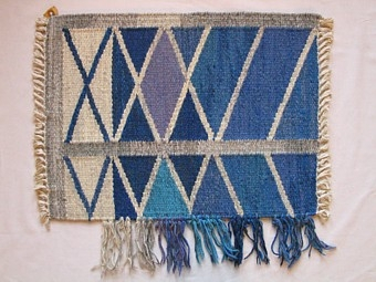 Mattprovet är vävt i rölakansteknik.
Mönstret består i grå diagonal ränder i ett rut mönster
på en blå botten.

Mönsterskiss finns KLh.D3:526 b

Mattprovet är vävt på Önnestads mattväveri