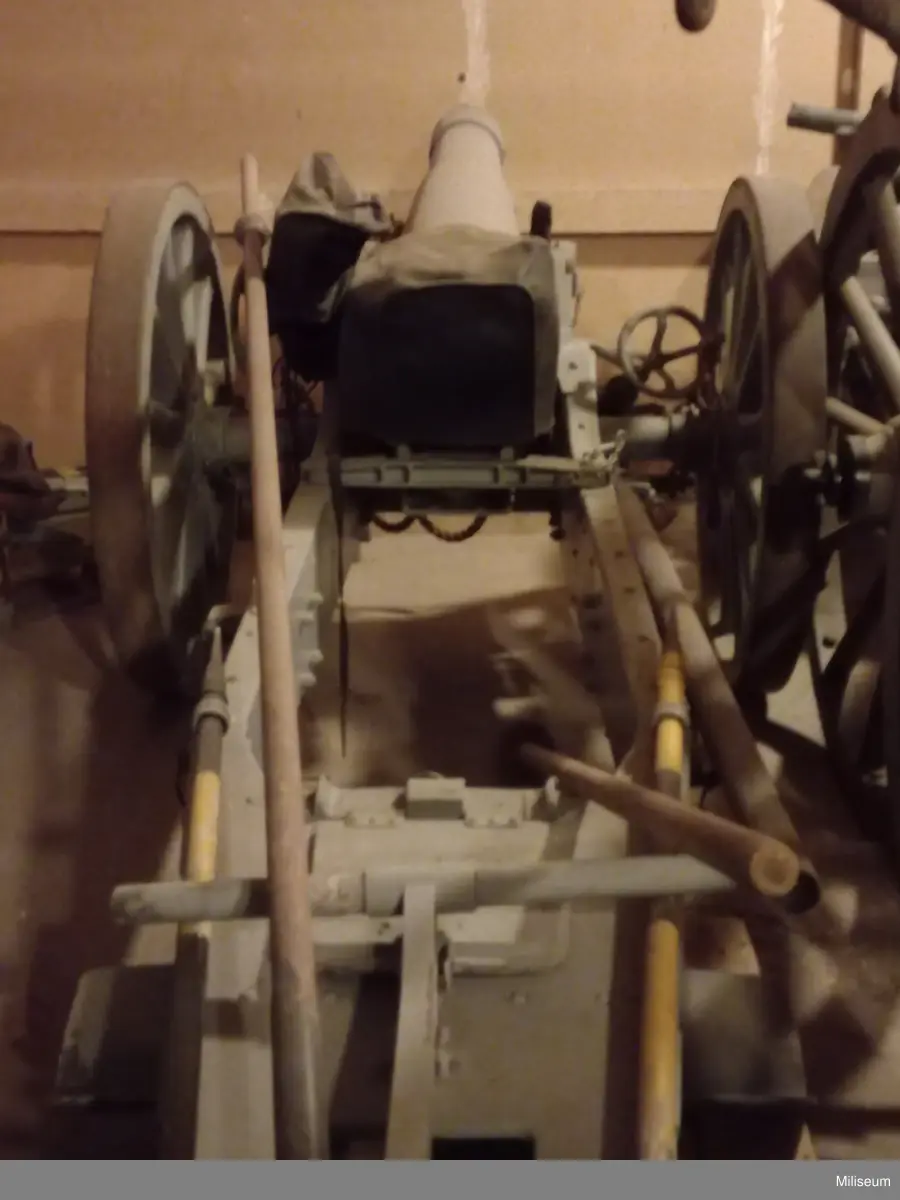 Delar: Tillbhörslåda, kilskydd, mekanism-kapell, mynnings-skydd. Samh. inv. Transportvagn/påhängshjul (sk Carelli) m/1906.