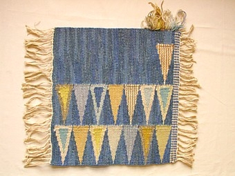 Mattprovet är vävt i rölakansteknik.
Mattans mönster består av en stor blå omönstrad spegel,
runt kanten är det vävt två rader pil mönster.

Skiss finns

Mattprovet är vävt på Önnestads mattväveri.

Finns äv. i ljusblått (inv.nr 1213) och rött (inv.nr 1214).