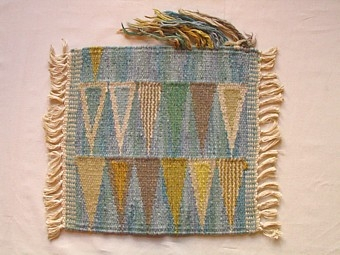 Mattprovet är vävt i rölakansteknik.
Mattans mönster består av en grå omönstrad spegel som inramas av två rader pilar
i olika färgskiftningar.

Skiss finns

Mattprovet är vävt på Önnestads mattväveri.

Finns äv. i mörkblått (inv.nr 1212) och rött (inv.nr 1214).