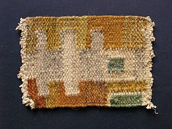 Mattprovet är vävt i rölakansteknik.
Mattans mönster består av blå kuber på grå botten, mellan kuberna är det vävt
"kammar" också i blått, detta bildar sammanhängande rader.
Totalt är det fem mönsterränder.

Skiss finns.

Mattprovet är vävt på Önnestads mattväveri.

Se också inv.nr 1221.