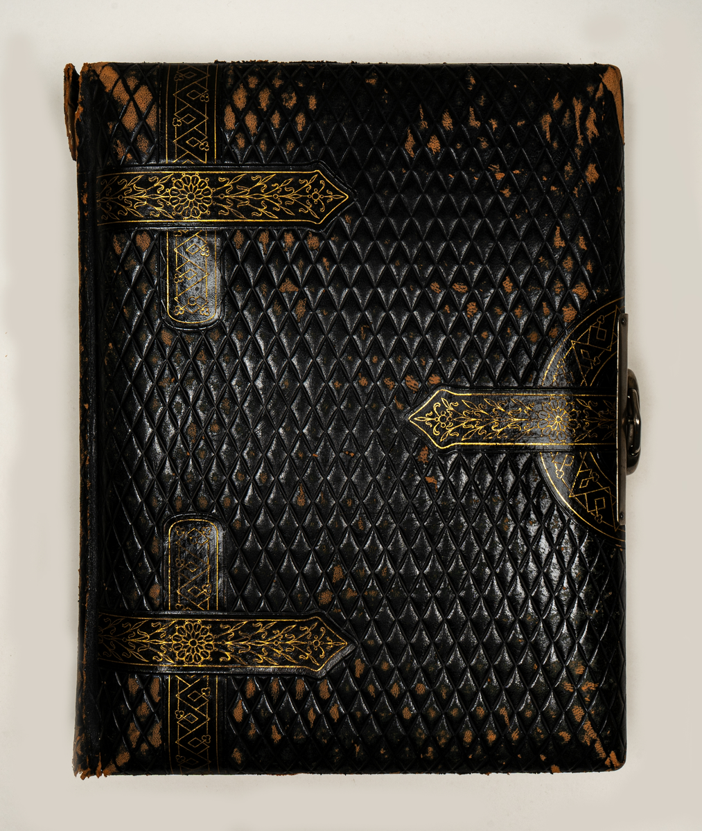 Fotoalbum, brunt skinn. "Beslagsornamentik" i relief, lås.