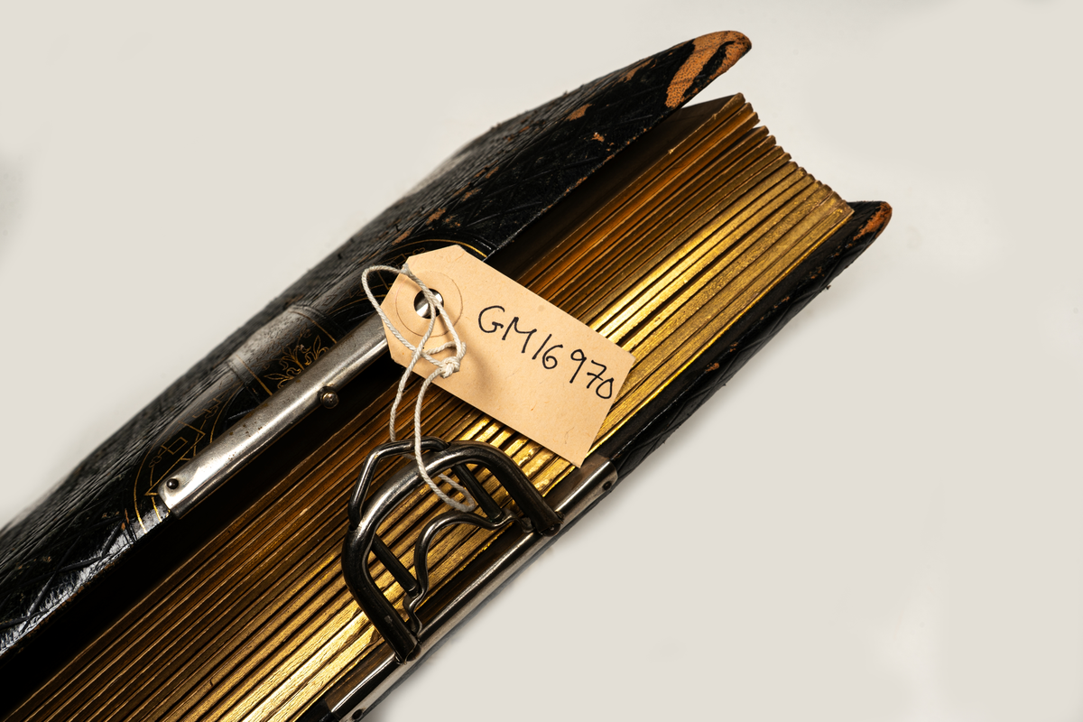 Fotoalbum, brunt skinn. "Beslagsornamentik" i relief, lås.