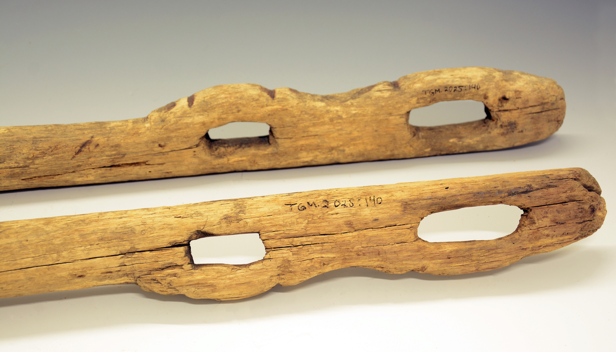 To skjeker med ornamentert avslutning rundt to hull. Til hestekjøretøy.