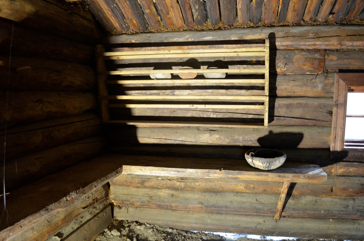 Tallerkenrekke med hylle nederst.