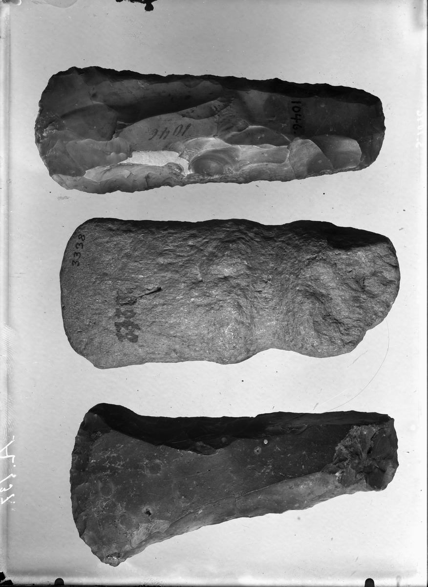 "1042-49. 8 Emner til Retmeisler af forskjellig Størrelse. Graa Flint. Længden varierer mellem 15 og 10 cm, Eggens Bredde mellem 6 og 3,5 cm. No. 1043 har udsvingede Eghjørner. De øvrige har afrundet Eg." Ny beskrivelse etter revisjon: 
Emne til øks av flint, stl: 118 mm, stbr: 56 mm.