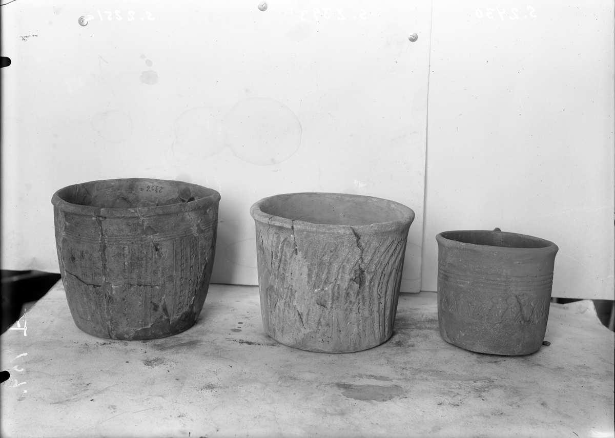 "2251 c. Brudstykker af en liden urtepotformet urne af asbestholdig lermasse."  Fem randskår og tjuesju avskallinger, samt løse fibrer av asbestholdig, spannformet leirkar. Godset er meget porøst og skaller av i flak. 