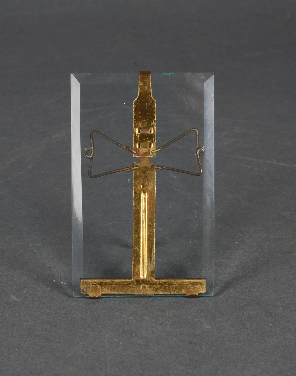 Stående, rektangulær bilderamme i form av en glassplate med et metallstativ på baksiden.
