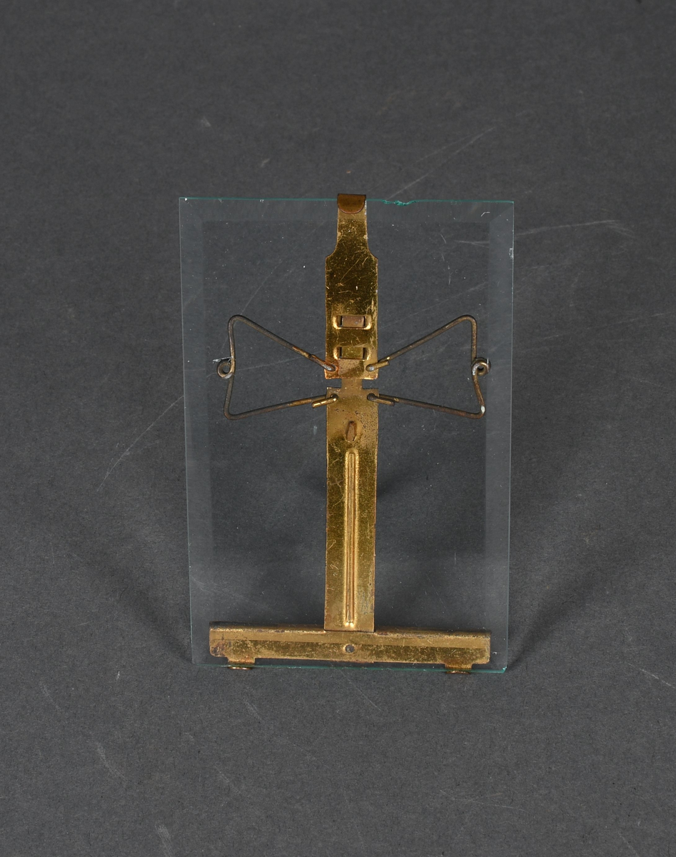 Stående, rektangulær bilderamme i form av en glassplate med et metallstativ på baksiden.
